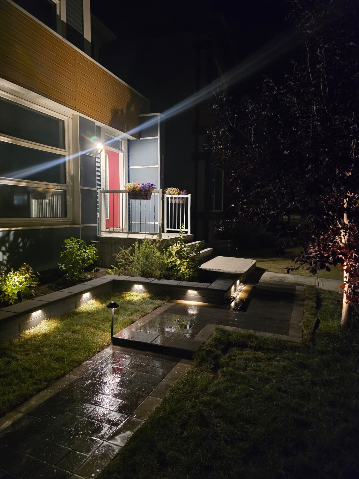 Sunken patio with outdoor lighting at night — Edmonton